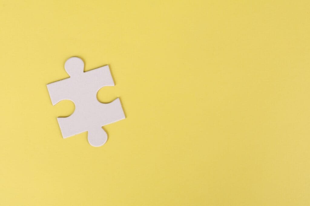 White puzzle piece on yellow background