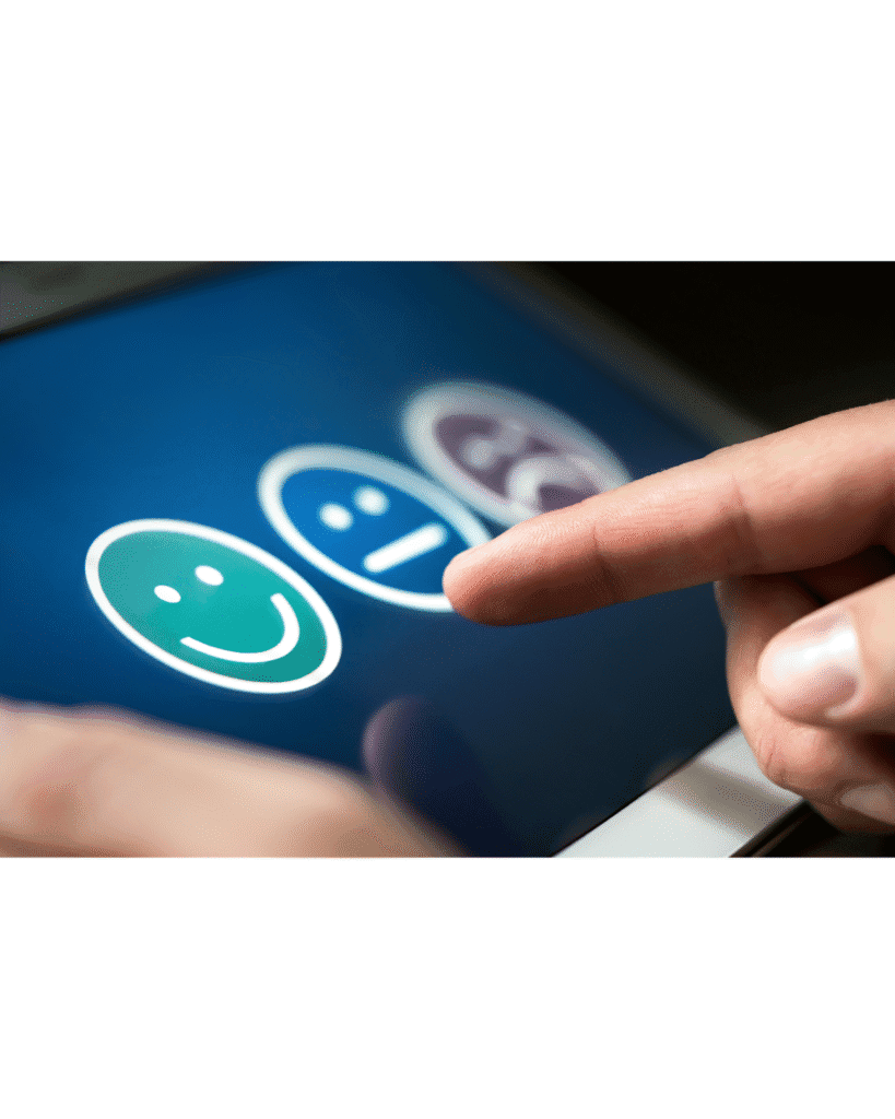 Finger selecting happy face emoji on tablet